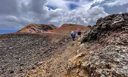 Personas caminando sobre las rocas de volcán Chico.